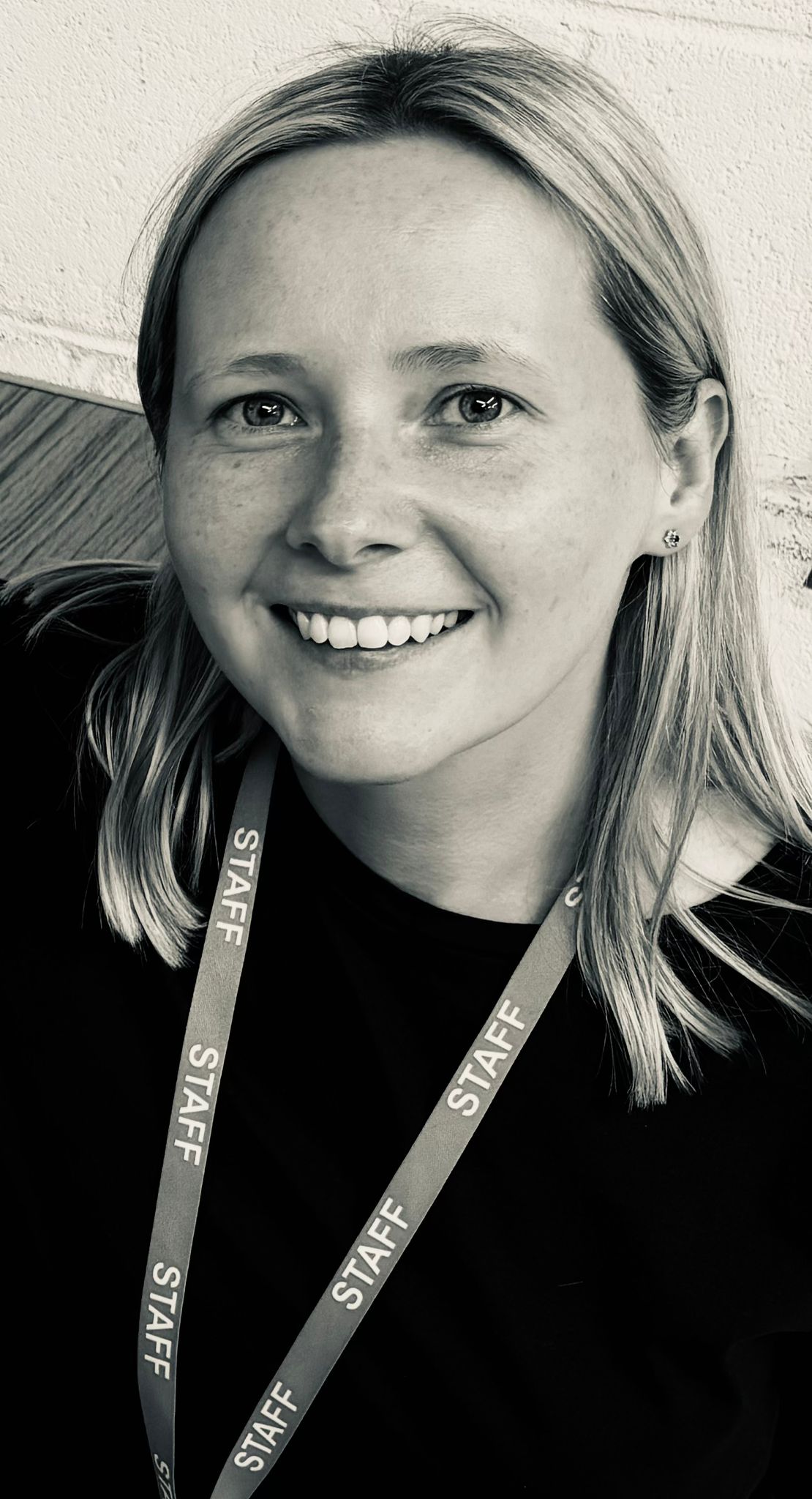 Portrait of Kate, a warm and smiling primary tutor wearing a staff lanyard